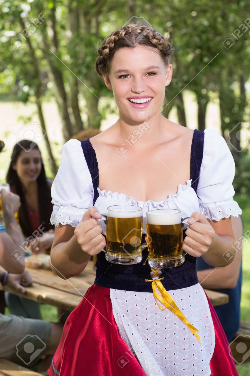 Pretty oktoberfest girl smiling at camera on a sunny day - 38104986