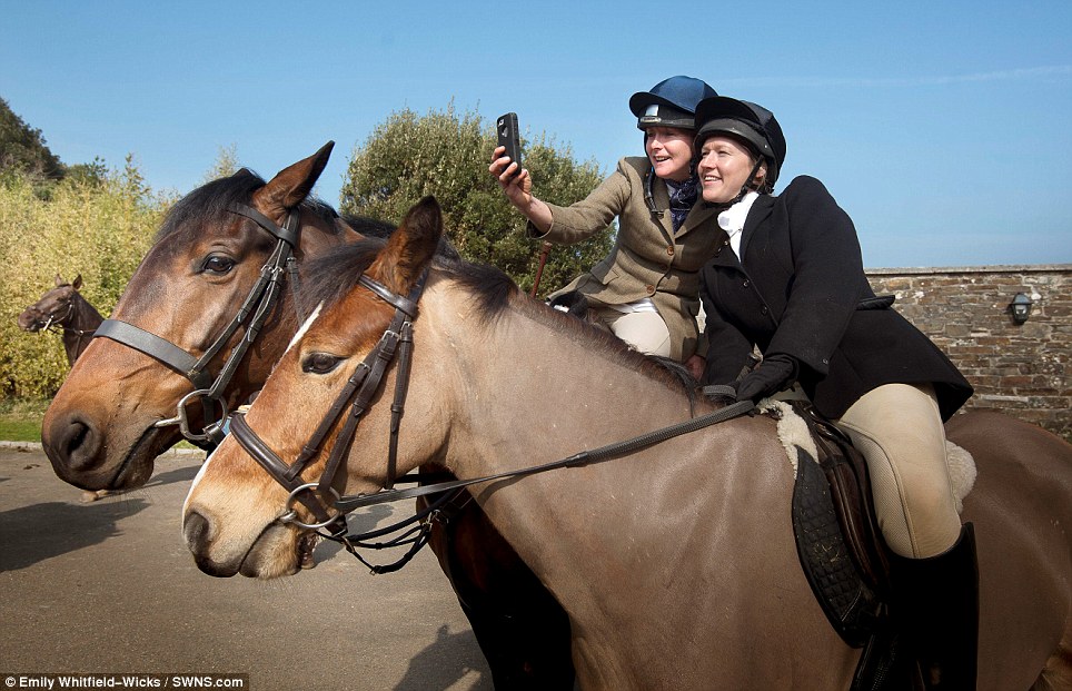 Smile! A couple of huntswomen take a selfie as they enjoy the sunshine at Pentille Castle in St Mellion yesterday - their mounts looked less than impressed, however