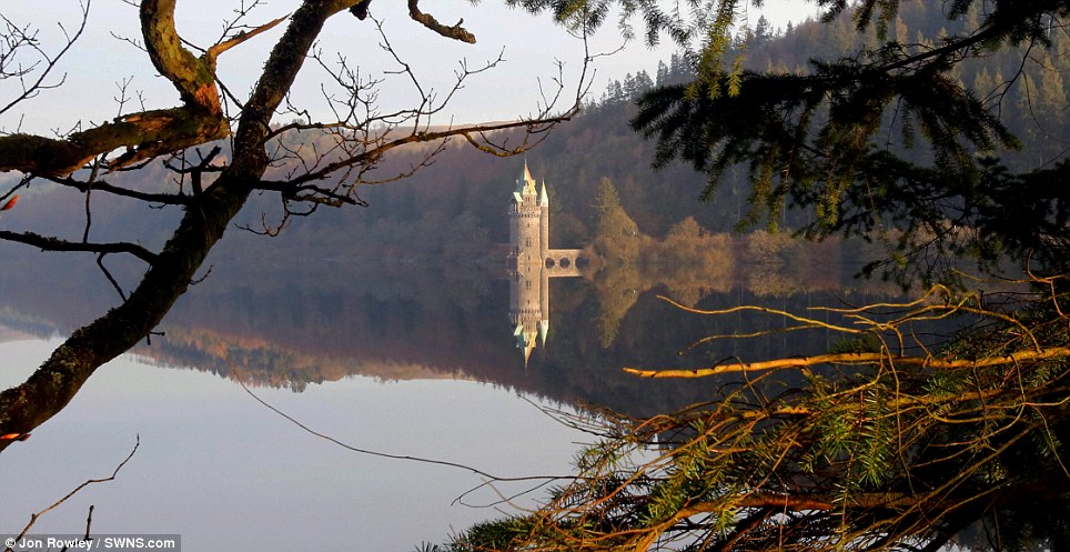 The sun rose over a perfectly still  Lake Vyrnwy, in Powys, Wales, this morning, reflecting the stunning landscape as Britain enjoyed unseasonably warm weather
